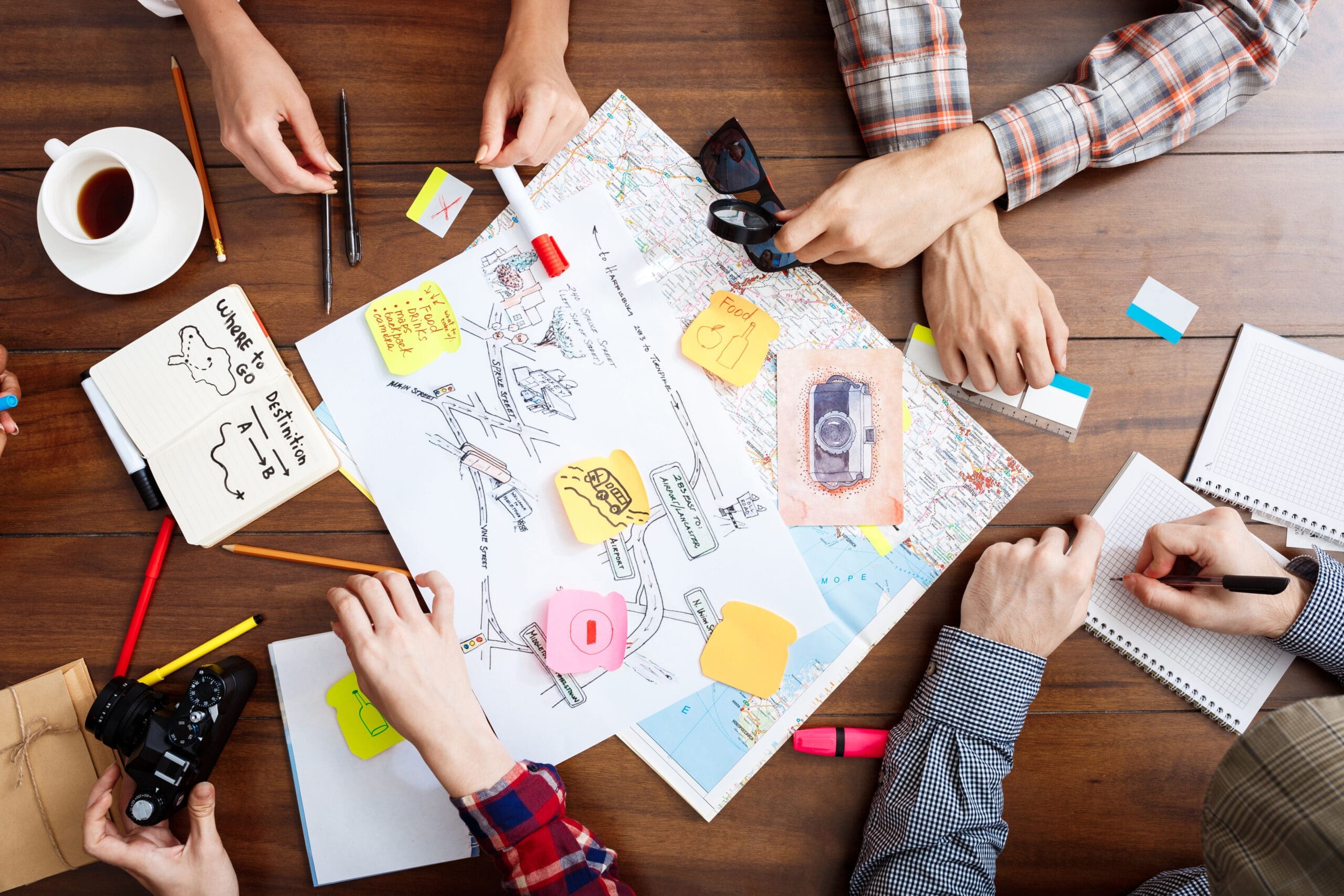 Picture of businessmen's hands on wooden table with documents and drafts Humanize Your Brand with People & Process